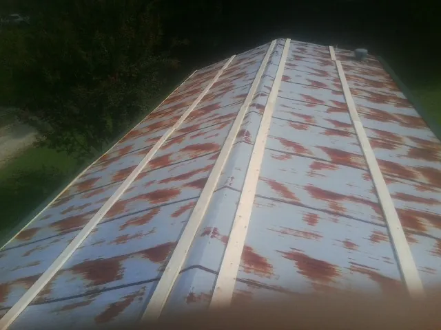 Rusted metal roof panels with new wood purlins before replacement — Storm Damage Roof Repair in Perham by Roofing Brothers