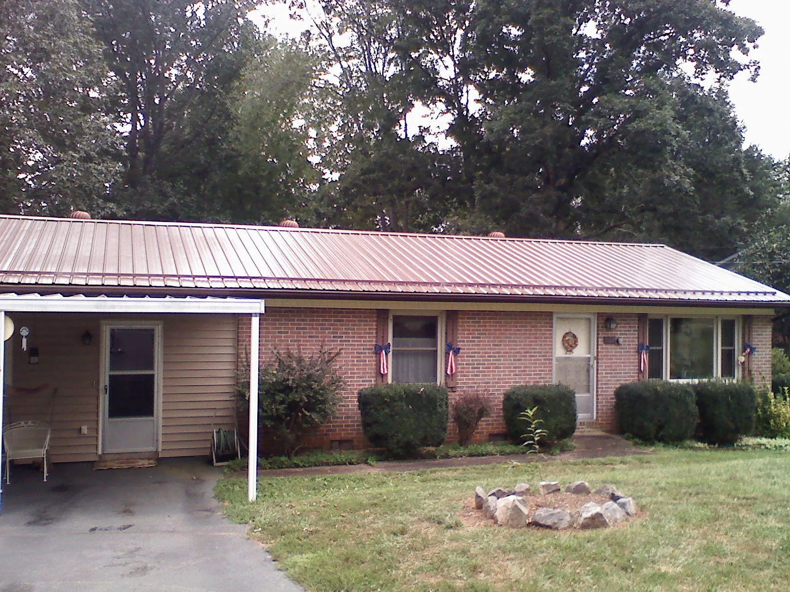 Bronze metal roof and carport on a brick ranch home — Roof Repair work by our crew in Perham